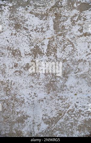Old, gray concrete wall with peeling white paint Stock Photo