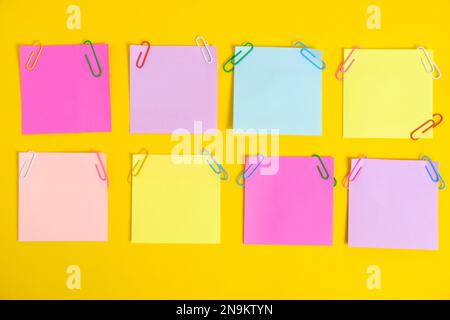 Colorful stickers for notes and paper clips yellow background Stock Photo