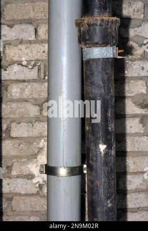 Sewer and water pipes fixed on a bricks with cement wall, plumbing fixing concept of water supply and sewer services, selective focus of the services Stock Photo