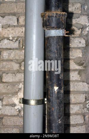 Sewer and water pipes fixed on a bricks with cement wall, plumbing fixing concept of water supply and sewer services, selective focus of the services Stock Photo