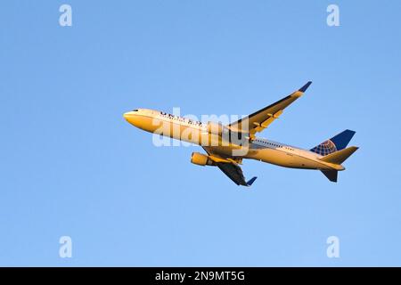 London, United Kingdom - February 2023:  United Airlines Boeing 767 jet (registration N686UA) climbing after take off at dusk against a clear blue sky Stock Photo