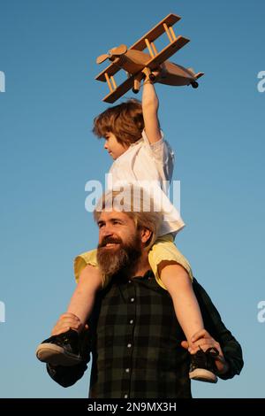 Kid boy pilot. Father and son playing with wooden airplane Stock Photo ...