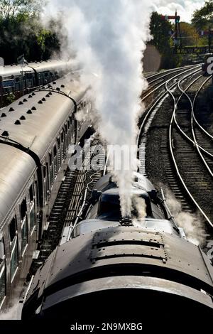Highley, Shropshire, UK - October 2021: View looking down on a vintage locomotive on the Severn Valley Railway as it releases steam from its boiler Stock Photo