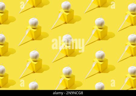 Pattern with white apple on yellow cube-shaped stand and white plastic fork. Stock Photo