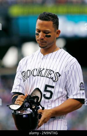 Colorado Rockies' Carlos Gonzalez takes a practice swing as he