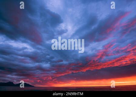Dramatic vibrant sunrise clouds at Kaikoura on east coast of New Zealand's South Island; South Island, New Zealand Stock Photo