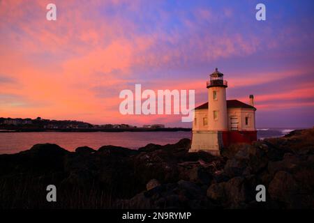 Coquille River Light on the rugged and rocky Oregon coast with golden sunrise light over the horizon; Bandon, Oregon, United States of America Stock Photo