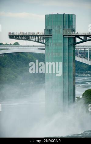 Tourists stand on a lookout tower at Niagara Falls in New York, USA; Niagara Falls, New York, United States of America Stock Photo