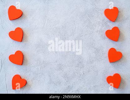 Frame made of Red white and pink confetti in the form of hearts on concrete background. Valentines day backdrop. Flat lay. Template for banner or party invitation Stock Photo
