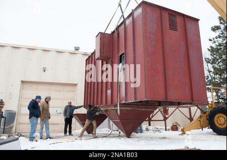 Group of men moving a huge metal storage unit; Lincoln, Nebraska, United States of America Stock Photo