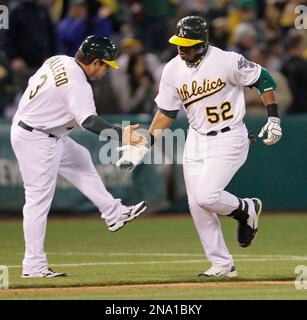 Oakland Athletics' Yoenis Cespedes, right, celebrates his solo home run  with teammate Josh Reddick (16) during the fourth inning of the second game  of a doubleheader baseball game against the Seattle Mariners