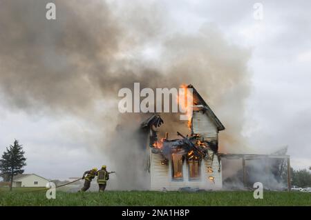 Local fire fighters use a controlled burning of a house for practice; Palmyra, Nebraska, United States of America Stock Photo