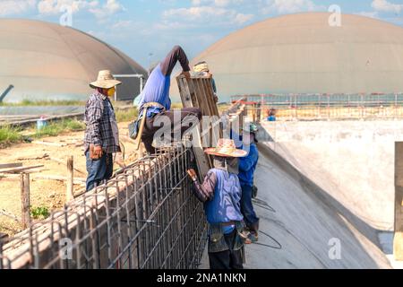Workers are lifting formwork for concrete pouring for treatment pond. Stock Photo