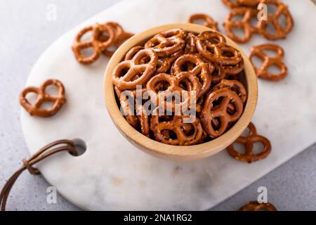 Mini pretzels in a wooden bowl, salty healthy snack Stock Photo