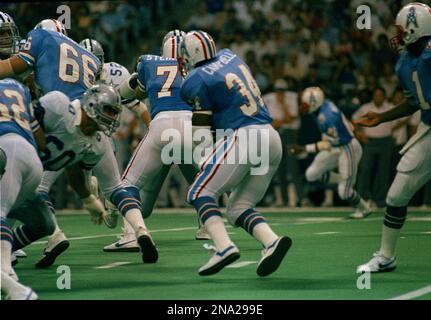 Houston Oilers' running back Earl Campbell (34) pops over his right tackle  slot to pickup 13-yards in the first quarter of the NFL game at Houston  Sunday, Oct. 26, 1986. Cincinnati Bengals'