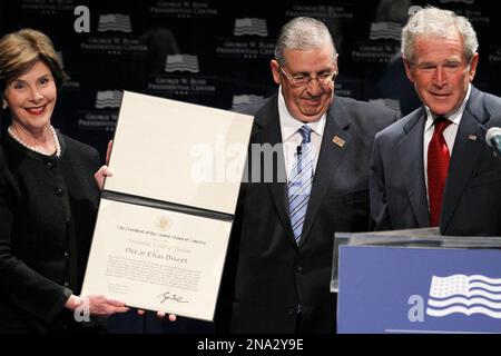 President George W. Bush (C) accepts a football jersey denoting