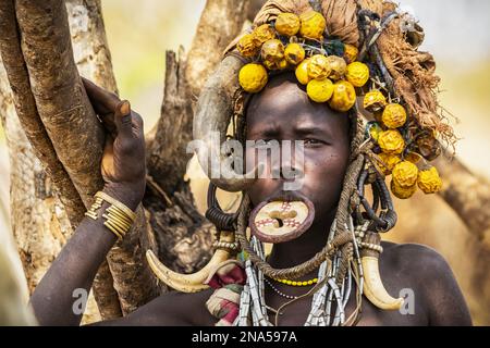 Mursi woman wearing a lip plate in a village in Mago National Park; Omo Valley, Ethiopia Stock Photo
