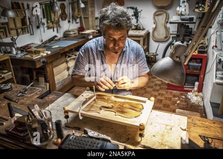 Violin craftsman; Venice, Italy Stock Photo