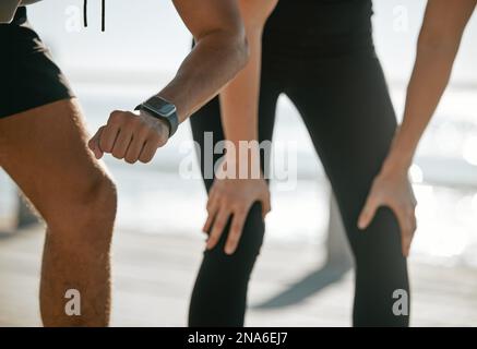 Running couple, time and smartwatch with fitness and check heart rate with cardio and outdoor workout. Legs, hands and cardiology with runner black Stock Photo