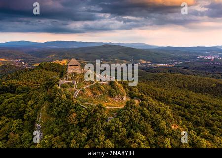 Salgotarjan, Hungary - Aerial view of Salgo Castle (Salgo vara) in Nograd county with a golden and blue sunset sky and green foliage on a summer after Stock Photo