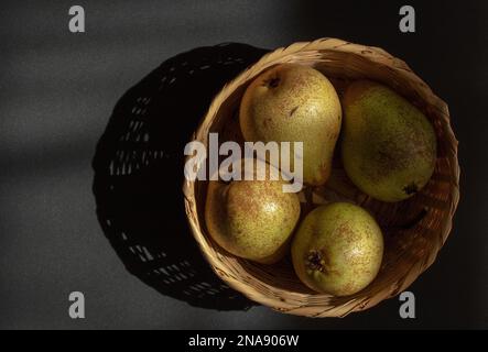 Pears seen in a basket on a dark background., Stock Photo