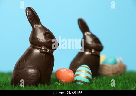 Chocolate Easter bunnies and eggs on green grass Stock Photo