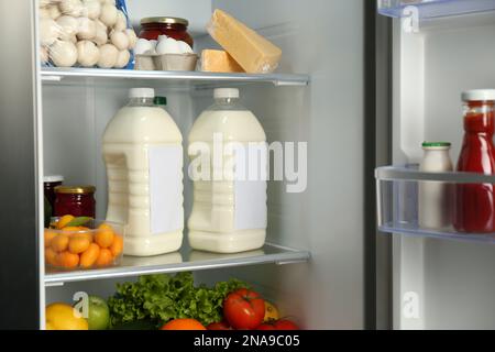 Gallons of milk and different products in refrigerator, closeup Stock Photo