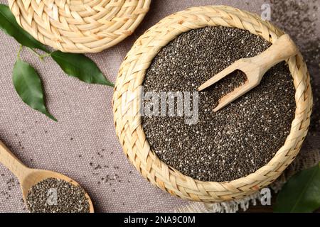 Wicker box and wooden spoon with chia seeds on table, flat lay Stock Photo
