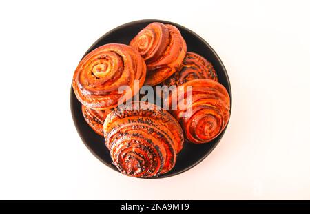 Sweet homemade cinnamon buns on a black ceramic plate. Stock Photo