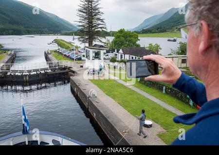 A traveler aboard a boat photographs The Caledonian Canal near Loch Oich, Scotland. Stock Photo