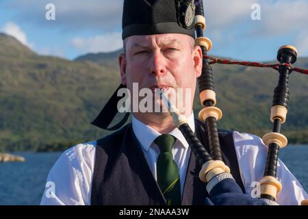 A Scottish bagpiper plays bagpipes in Kyle of Lochalsh, Scotland; Kyle of Lochalsh, Scotland Stock Photo