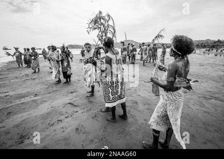 Village women in tapa bark cloth dresses preparing to perform traditional sing sing Melanesian tribal dance in Morobe Bay, Morobe Province,  Papua New Stock Photo