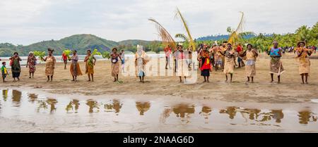 Village women in tapa bark cloth dresses preparing to perform traditional sing sing Melanesian tribal dance in Morobe Bay, Morobe Province,  Papua New Stock Photo