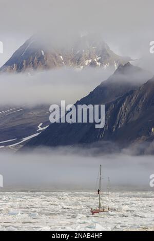 Sail boat navigates pack ice, Hornsund, Spitsbergen, Svalbard, Norway. Stock Photo