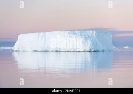 A tabular iceberg under the midnight sun of the Antarctic summer in the Weddell Sea, Antarctic Sound, Antarctica. Stock Photo