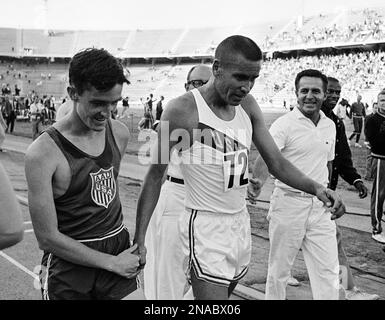 A smiling Gerry Lindgren, left, of Washington State congratulates Billy  Mills of the U.S. Marine Corps after Mills beat him by inches in the  six-mile run of the National AAU track and