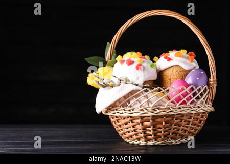 Traditional Easter cakes in wicker basket on dark background. Space for text Stock Photo