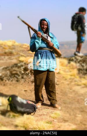 Squatter standing with a rifle and looking at the camera in Simien National Park in Ethiopia; Ethiopia Stock Photo