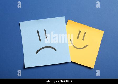 Stickers with sad and happy faces on blue background, flat lay Stock Photo