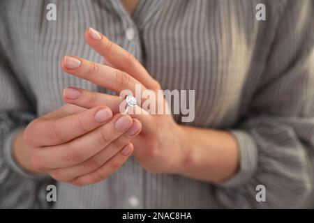 Woman taking off wedding ring, closeup. Divorce concept Stock Photo