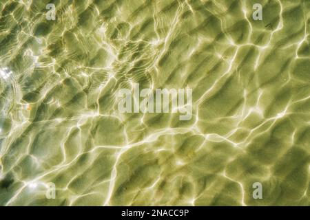 Wavy sand under the transparent sea water with a sunlight glimpse. Nature backgrounds and themes Stock Photo