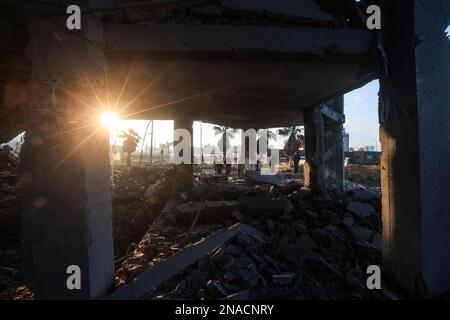 Gaza, Palestine. 13th Feb, 2023. Palestinians inspect a destroyed wedding hall after being attacked by Israeli aircraft, in Gaza. The Israeli army spokesperson said aircraft bombed a Hamas rocket manufacturing site and military installations in the Gaza Strip after Palestinian militants launched four rockets into southern Israel overnight. Credit: SOPA Images Limited/Alamy Live News Stock Photo
