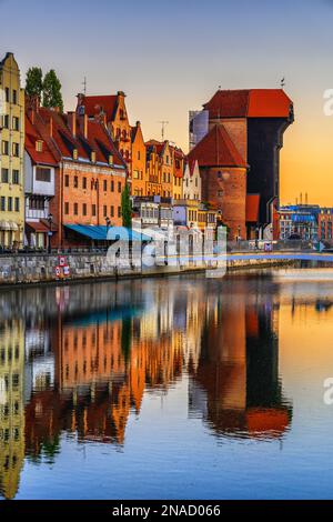 Old Town in city of Gdansk at sunrise in Poland, river view skyline with famous medieval Crane and mirror reflection in water. Stock Photo