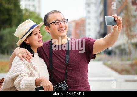 Happy multiracial couple of tourists taking a selfie together. Stock Photo