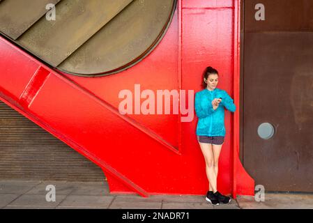 Smiling young woman having a break from exercising looking on sm Stock Photo