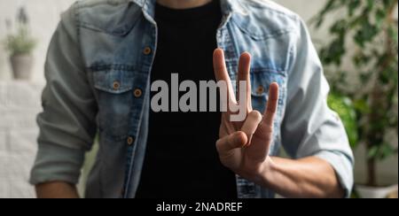 Sign language interpreter man translating a meeting to ASL, American Sign Language. Empty copy space for Editor's content Stock Photo
