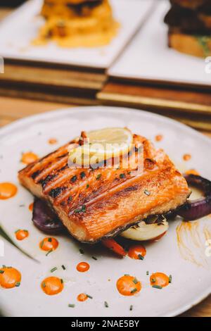 Gourmet grilled Norwegian salmon loin on a mattress of vegetables Stock Photo