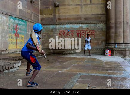 Children playing cricket on the ghats; Varanasi, India Stock Photo