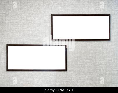 Two picture frames with copy space for text hanging on the wall with wallpaper. Mockup for design. Vacant poster. Stock Photo