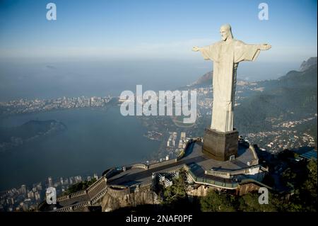 Christ the Redeemer statue at sunrise with Botafogo Beach and the bay down below. At a height of 130 feet, the statue is the world's tallest. It we... Stock Photo